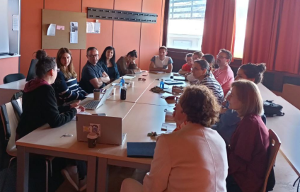 Persoas reunidas en torno a unha mesa de traballo